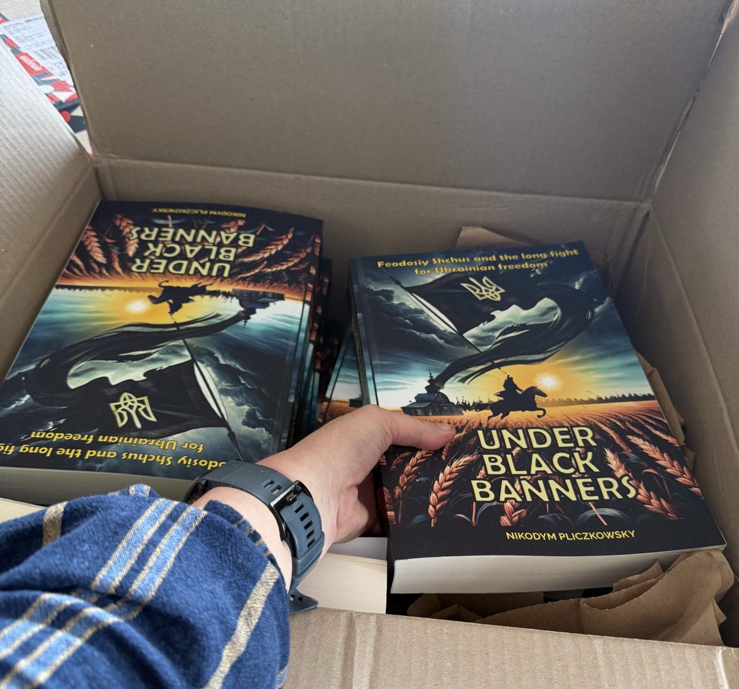 black banners box a hand reaching into a box of books under black banners