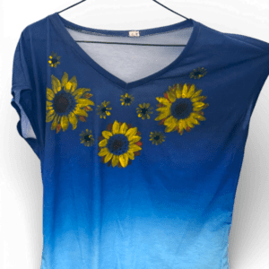 Blue gradient V-neck T-shirt with yellow sunflower embroidery on the front, hanging on a hanger.